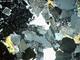Interlocked crystal sheets, from a microscope view of granite.